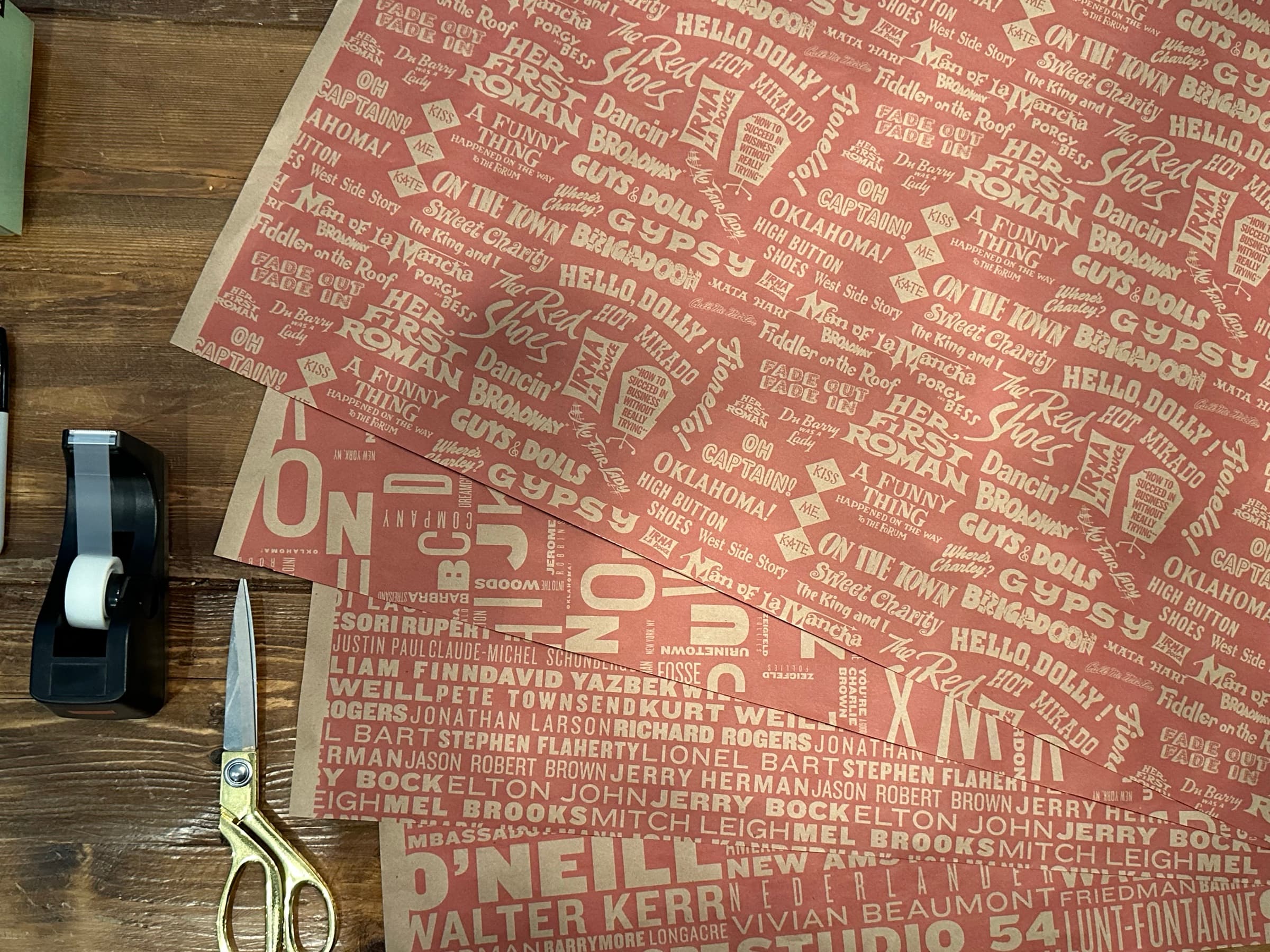A second sheet of the alphabet paper layered over the first at an angle: oversized letter forms (D, J, U, X, Y, Z) anchor the foreground, and the cream type of show titles and performer names disappears into the depth of the layered fold.
