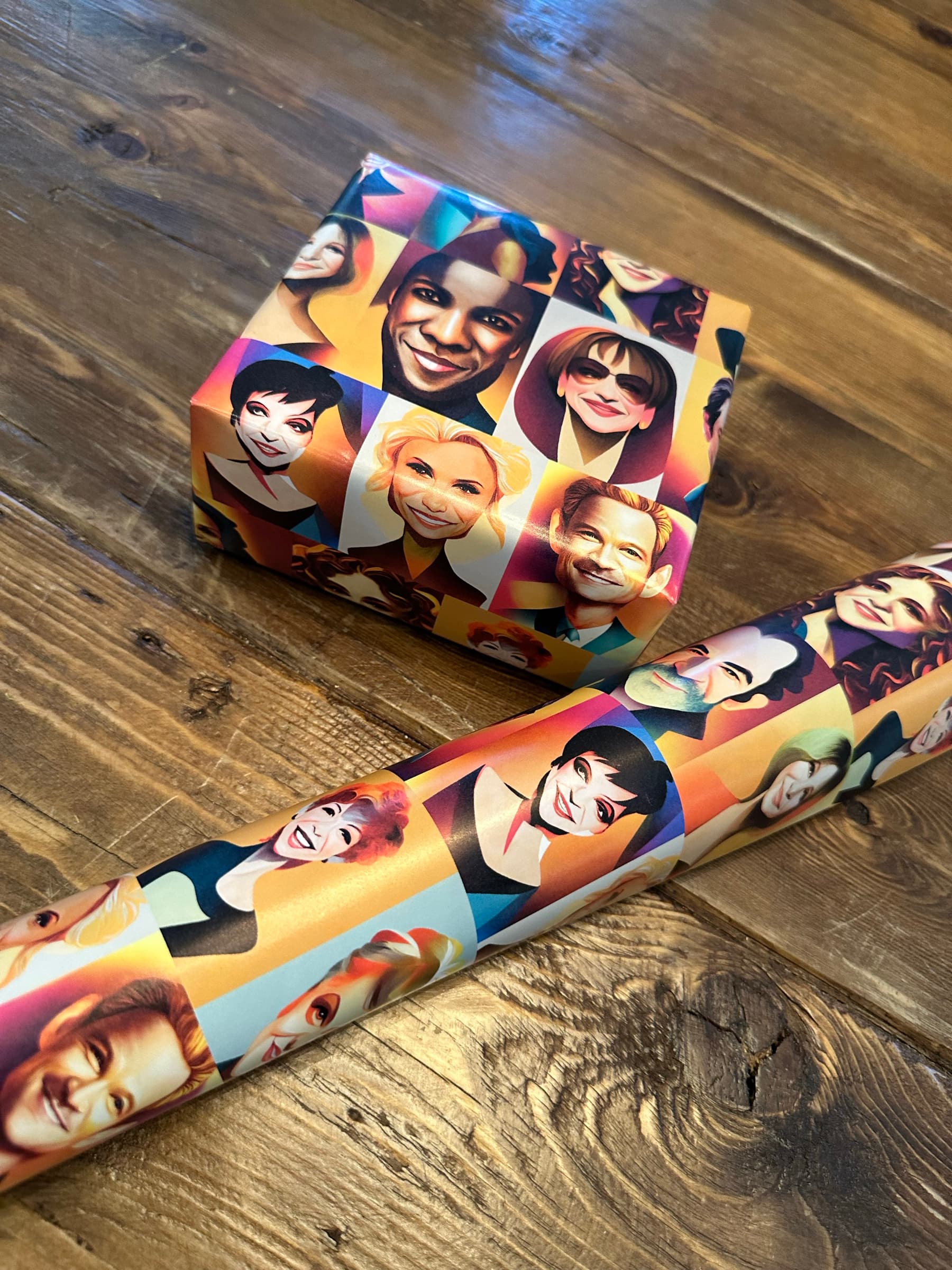 The portrait paper as a roll lying alongside a wrapped box on a wooden floor: roll on the right with portraits visible spiraling around it, wrapped box on the left with the grid wrapping cleanly around the top corner.